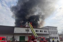 V Praze na Žižkově hoří střecha ubytovny, hasiči lidi zachraňují pomocí žebříků